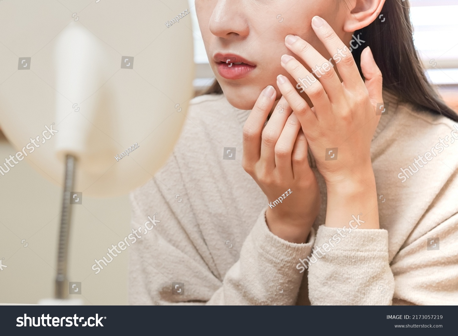 Dermatology, puberty asian young woman, girl looking into mirror, allergy presenting an allergic reaction from cosmetic, red spot or  rash on face. Beauty care from skin problem by medical treatment. #2173057219