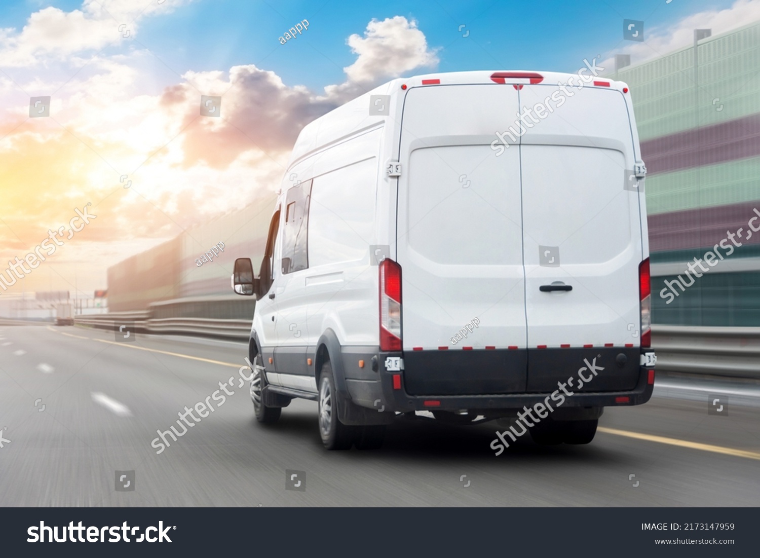 White mini bus is moving motion blur along city highway bypass road with beautiful sky before sunset. Fast express delivery service of goods and parcels #2173147959