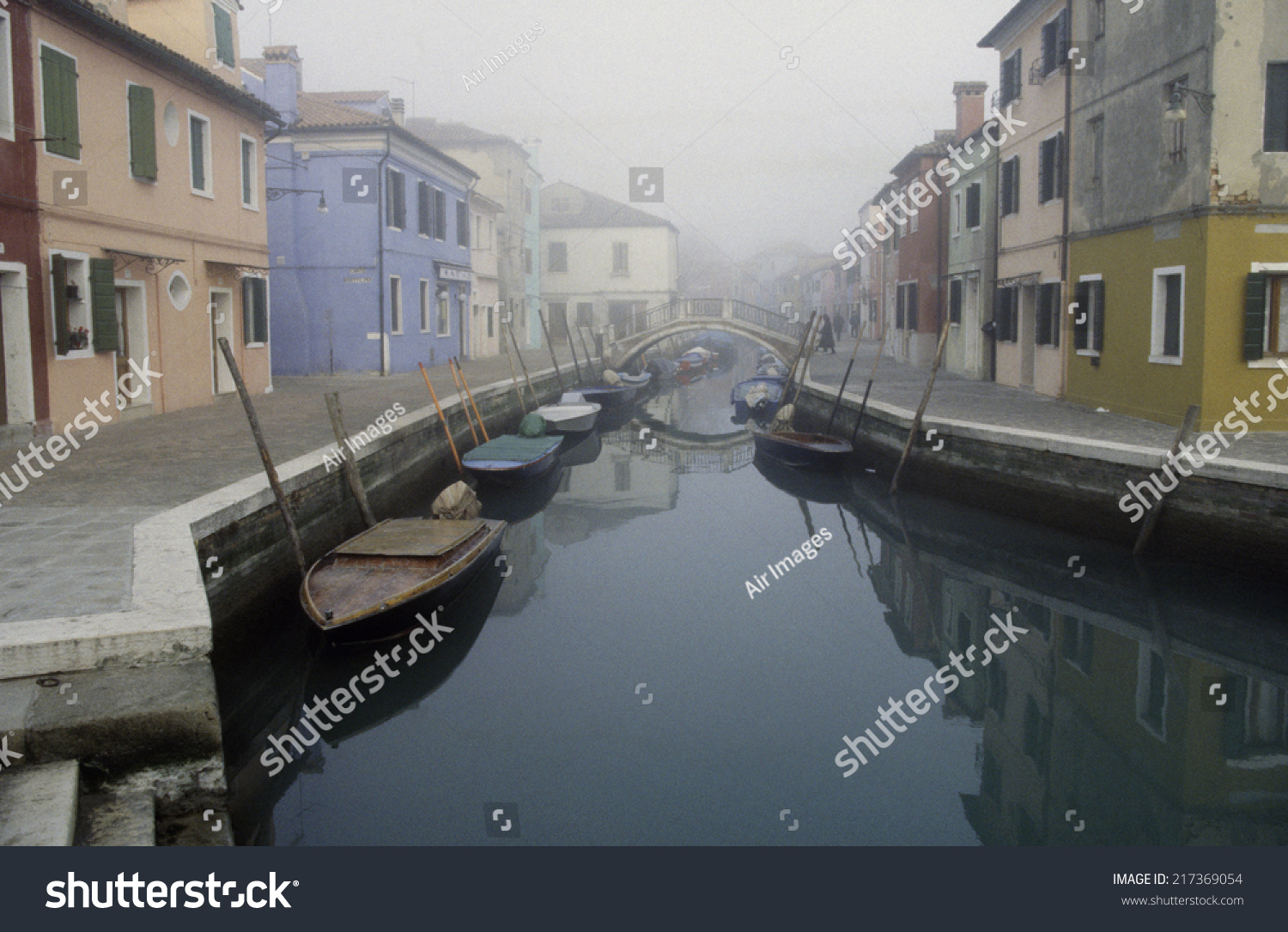 Tranquil canal streetscape in Burano, Venice, Italy #217369054