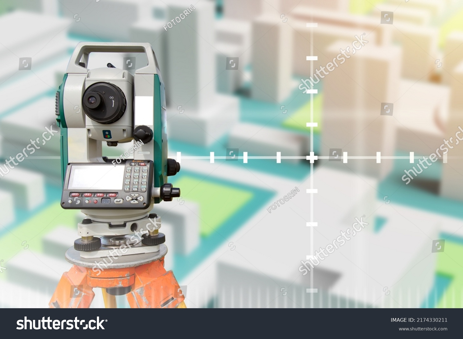 Device for surveyor. Optical theodelite on tripod. Place for text about geodesy. Equipment for topographic maps. Electronic theodelite for surveyor. Surveyor devise front blurred town. #2174330211