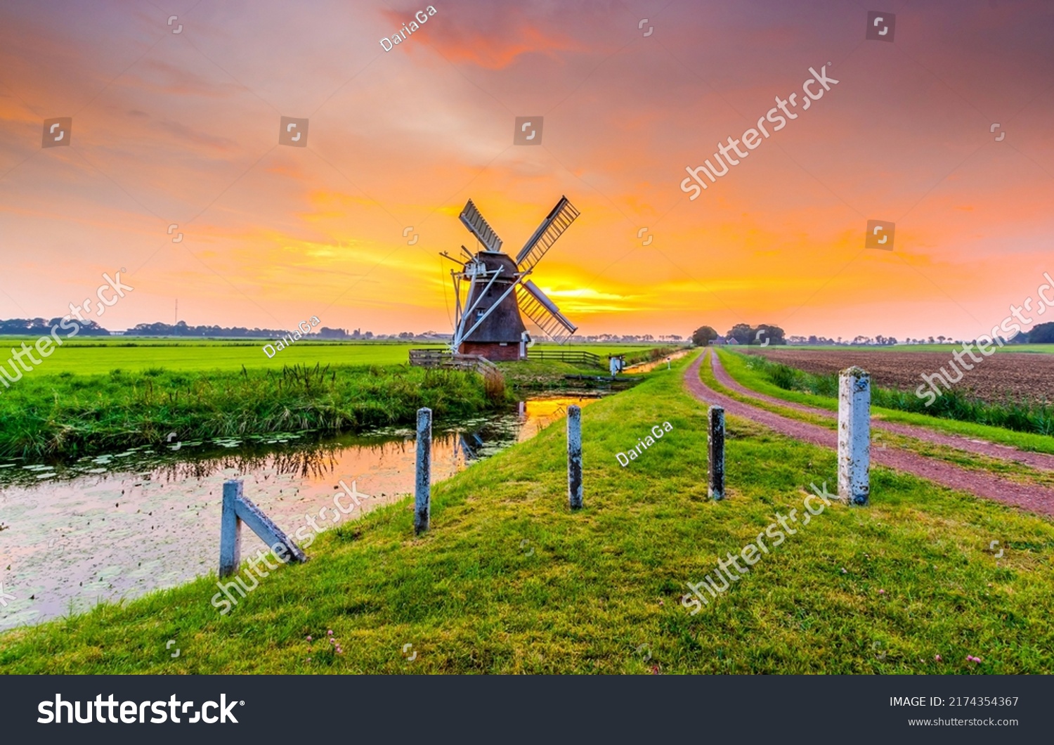 Mill by the river at sunset. Windmill farm at sunset #2174354367