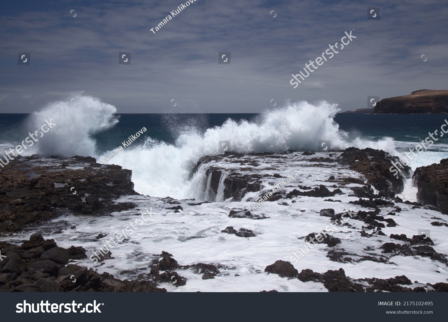 Gran Canaria, north west coast around natural swimming pools Salinas de Agaete, 
waves breaking against old eroded dark lava platform #2175102495