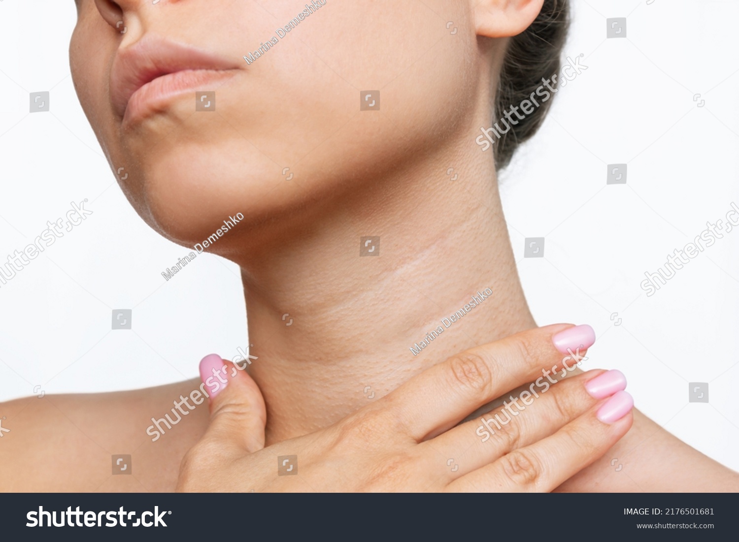 Cropped shot of a young woman touching her neck with her hand isolated on a white background. Lines on the neck. Wrinkles, age-related changes, rings of Venus, goosebumps #2176501681