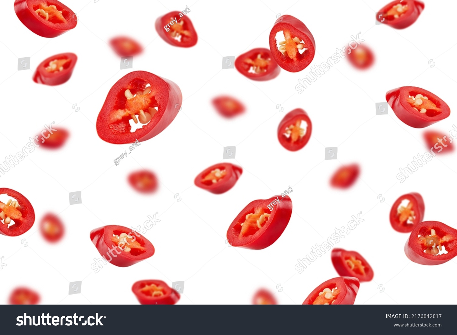 Falling sliced red hot chili peppers isolated on white background, selective focus #2176842817