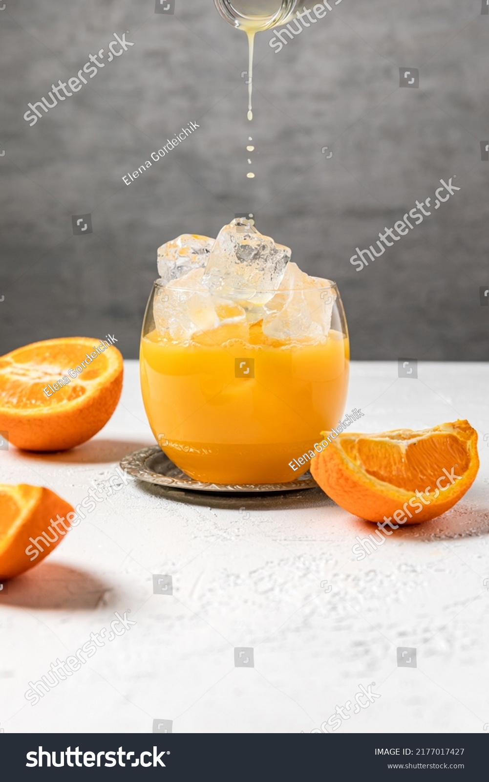 Bumble cold refreshing coffee drink with freshly squeezed orange juice, espresso and ice in the making. Pouring orange juice into the glass. #2177017427