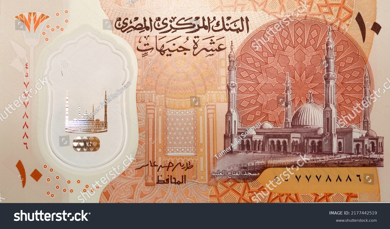 Large fragment of the obverse side of the new first Egyptian 10 LE EGP ten pounds plastic polymer banknote features Administrative capital's grand mosque Al-Fattah Al-Aleem, selective focus #2177442519