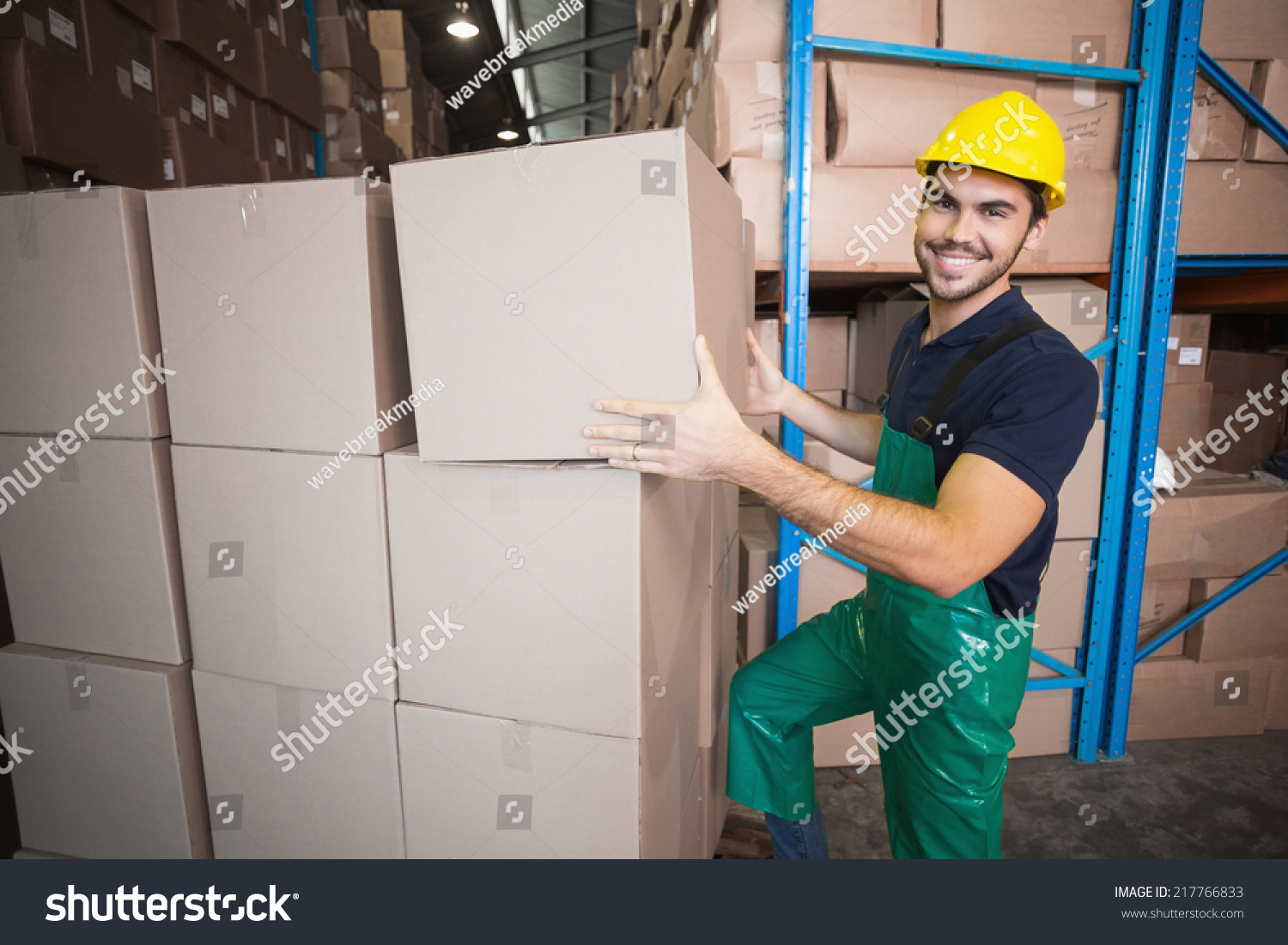 Warehouse worker loading up a pallet in a large warehouse #217766833