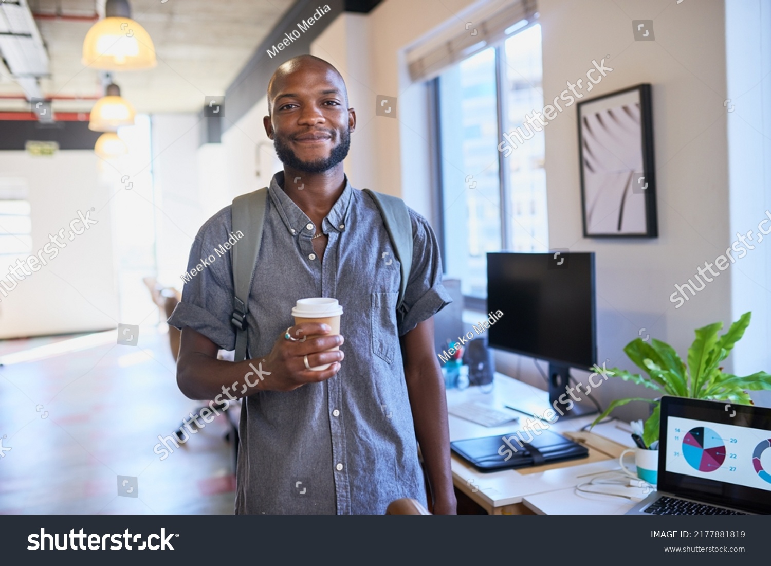 A Black trendy man arrives at the office with his coffee and backpack #2177881819