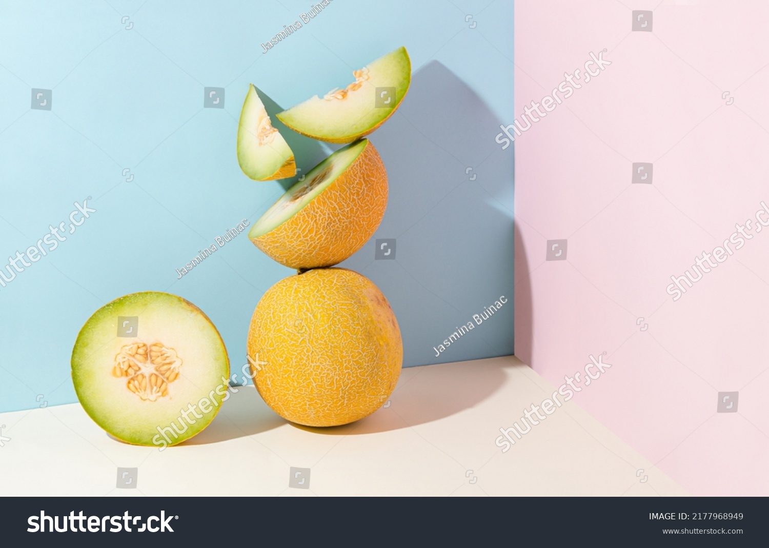 Minimal abstract creative summer fruit scene made with slices of juicy, fresh melon standing on isolated pastel beige, pink and blue background with copy space. Aesthetic concept of raw healthy food. #2177968949