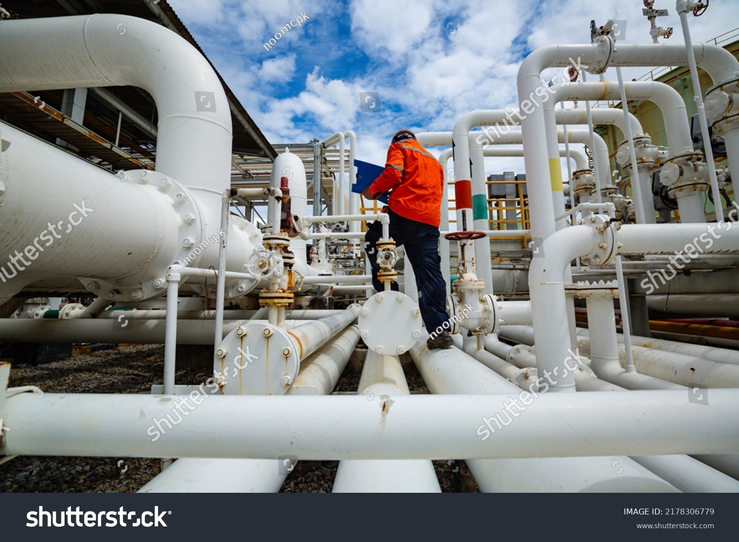 Male worker inspection at steel long pipes and pipe elbow in station oil factory during refinery valve of visual check record pipeline tank oil and gas industry #2178306779