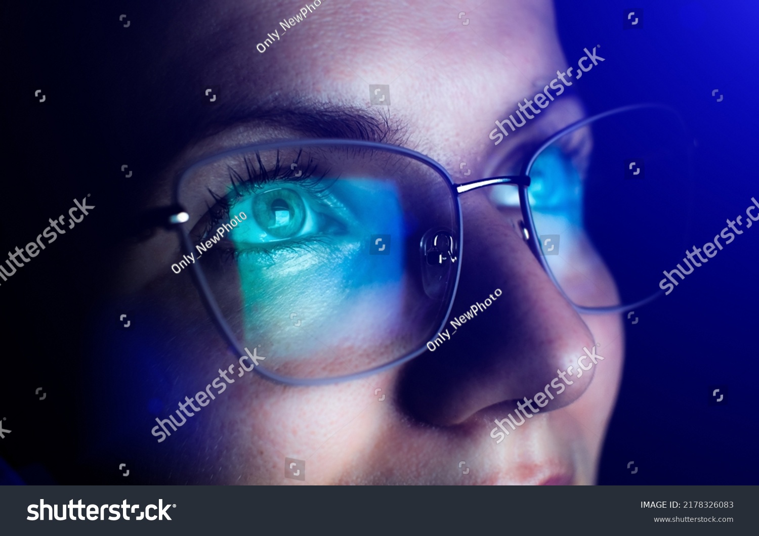 Girl works on internet. Reflection at the glasses from laptop.Close up of woman's eyes with black female glasses for working at a computer. Eye protection from blue light and rays. #2178326083