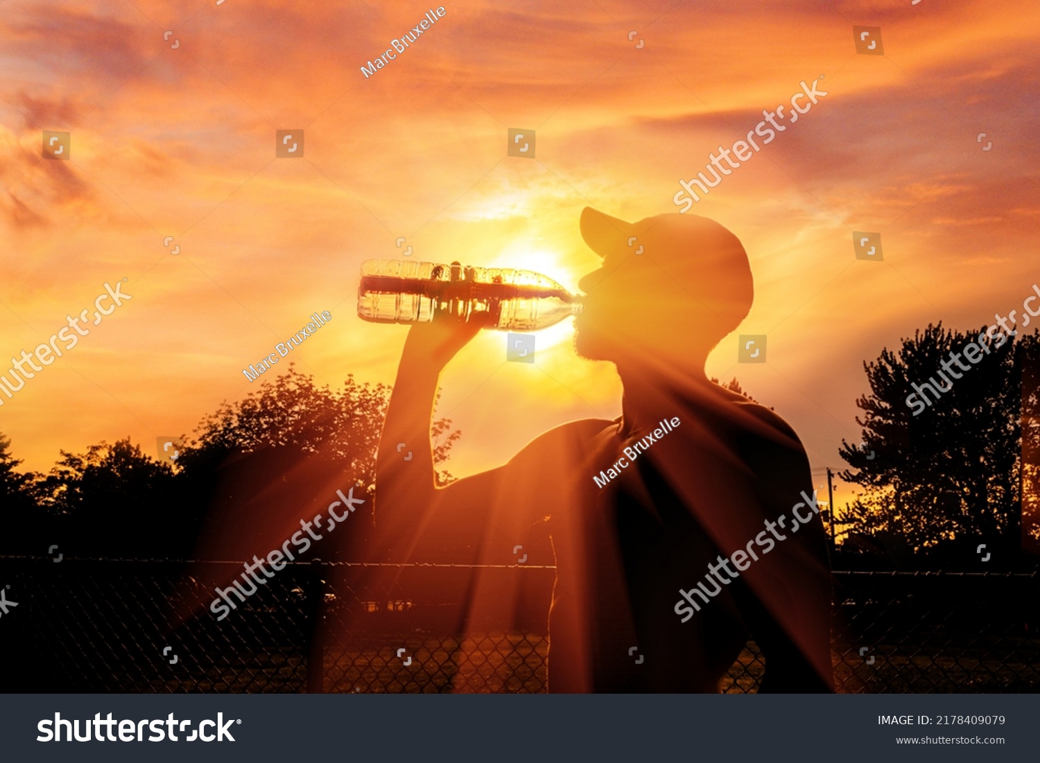 Silhouette of a man drinking water during heat wave #2178409079