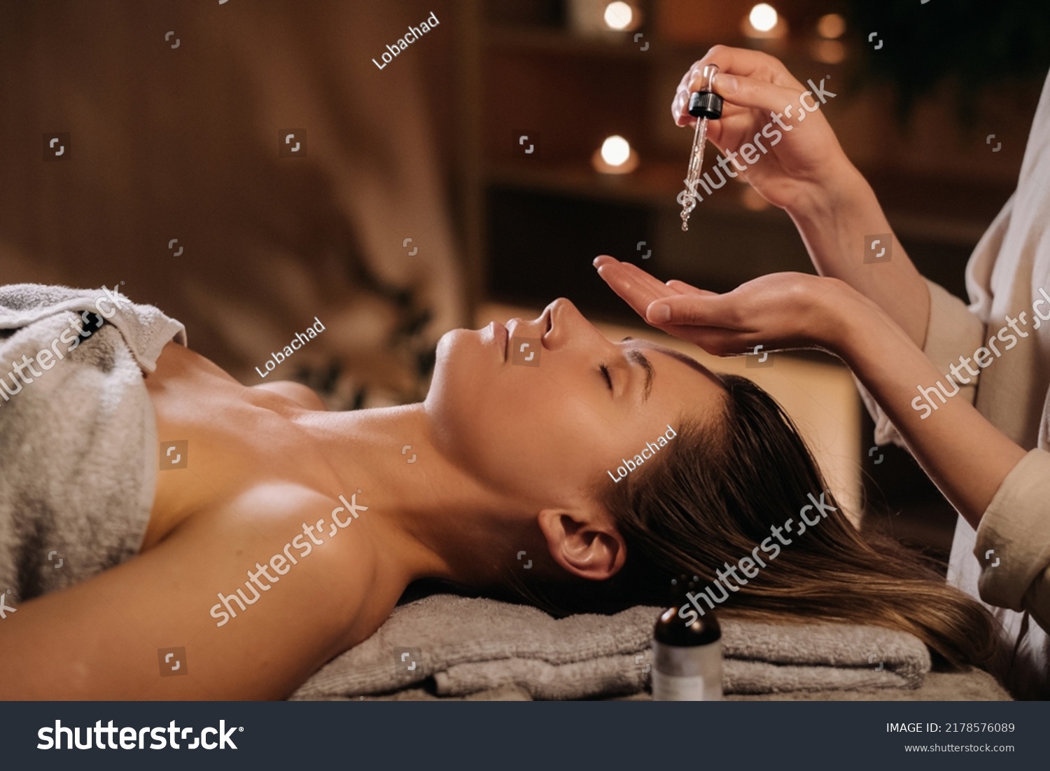 A female cosmetologist holds a pipette with essential oil before aromatherapy and massage to the patient. aromatherapy.Close-up. #2178576089