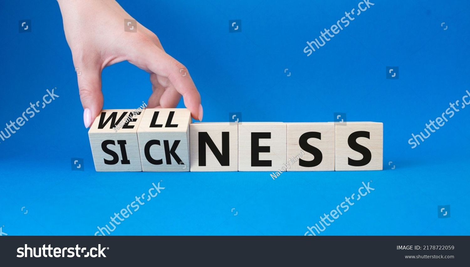 Wellness and Sickness symbol. Hand turns a cube and changes the word sickness to wellness. Beautiful blue background. Businessman hand. Business and wellness and sickness concept. Copy space #2178722059
