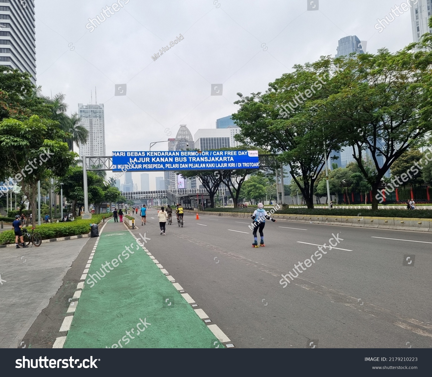 empty street on Sunday car free day, translate: car free day, right lane for transjakarta bus following by cyclist, runner and walker on left lane or sidewalk #2179210223