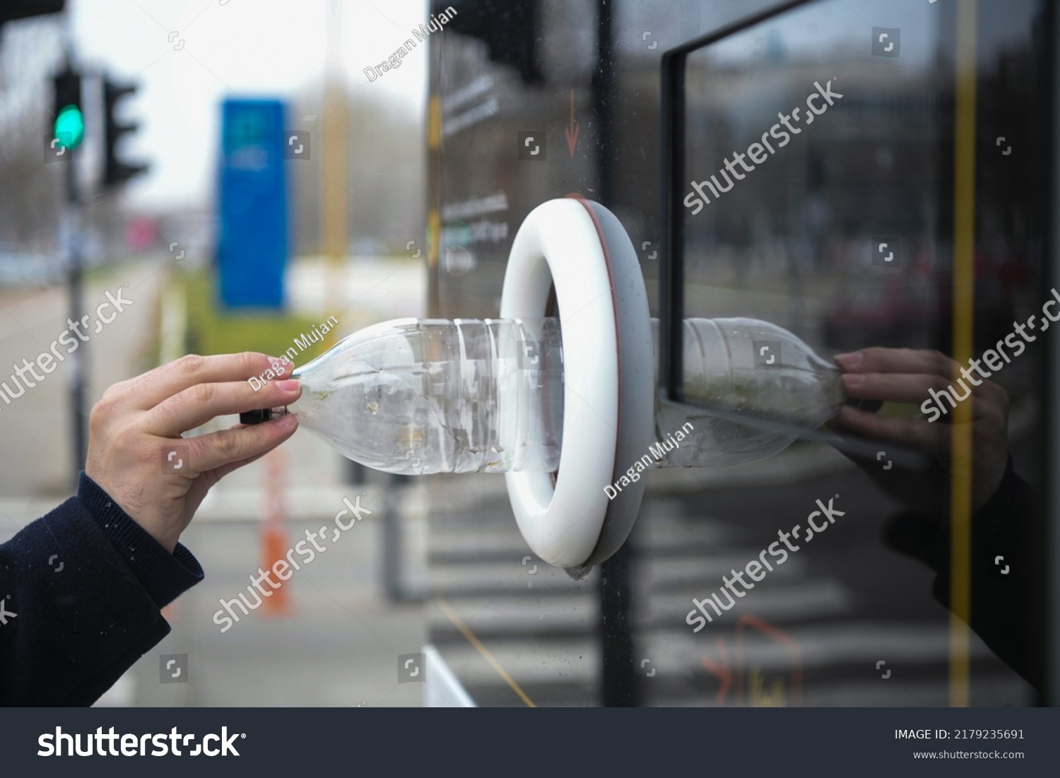 Reverse Vending Recycling Machine. Recycling machine that dispenses cash. Man hand puts plastic bottle to the machine. Shoppers return their bottles and cans. #2179235691