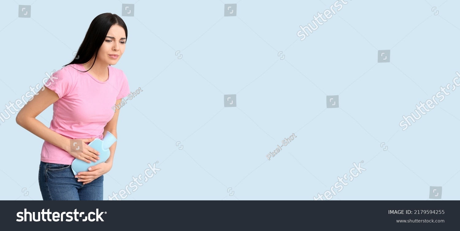 Young woman suffering from menstrual cramps on light blue background with space for text #2179594255