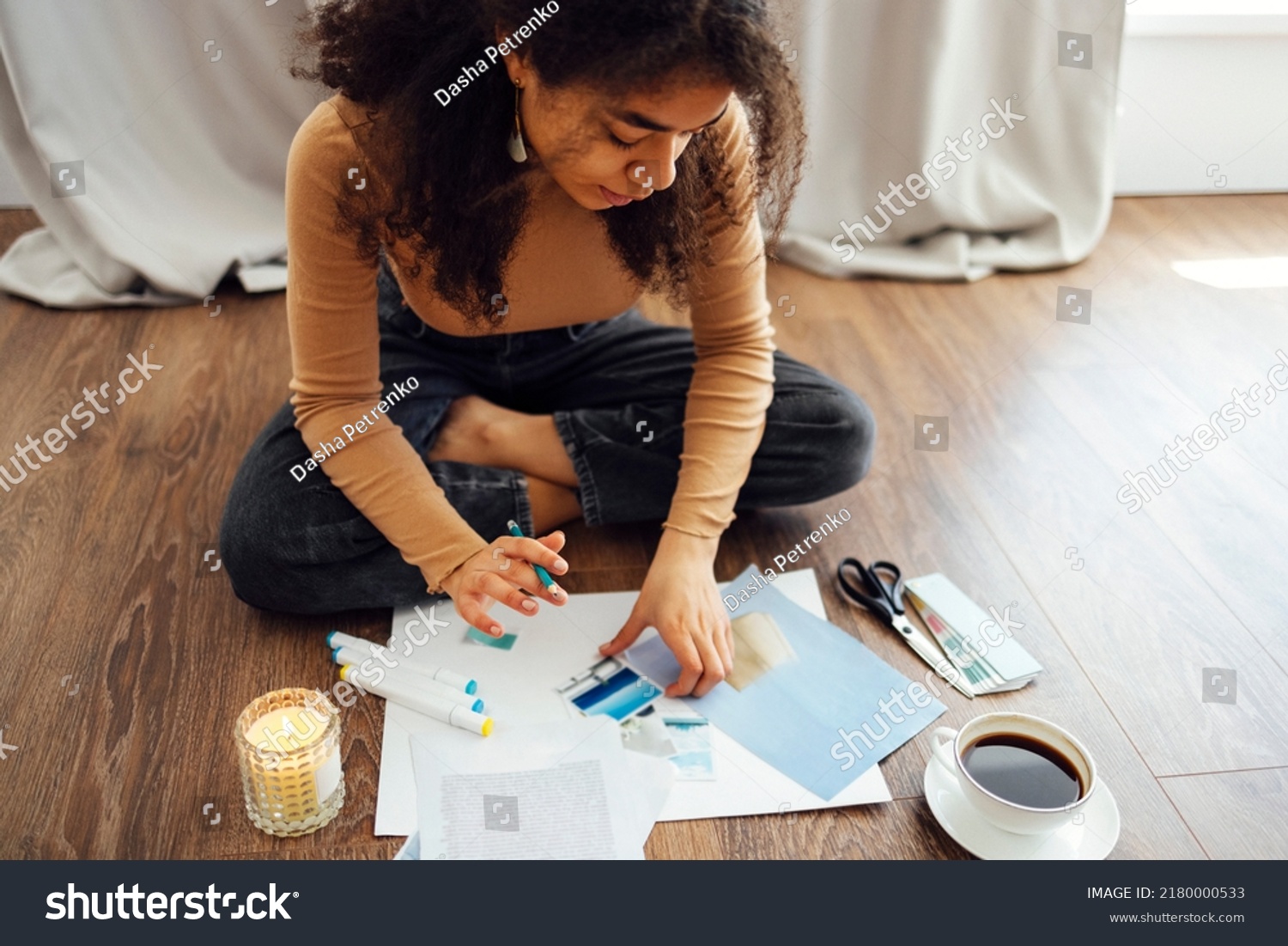 Young brunette african american woman creating her Feng Shui wish map using scissors. Dreams and wishes #2180000533