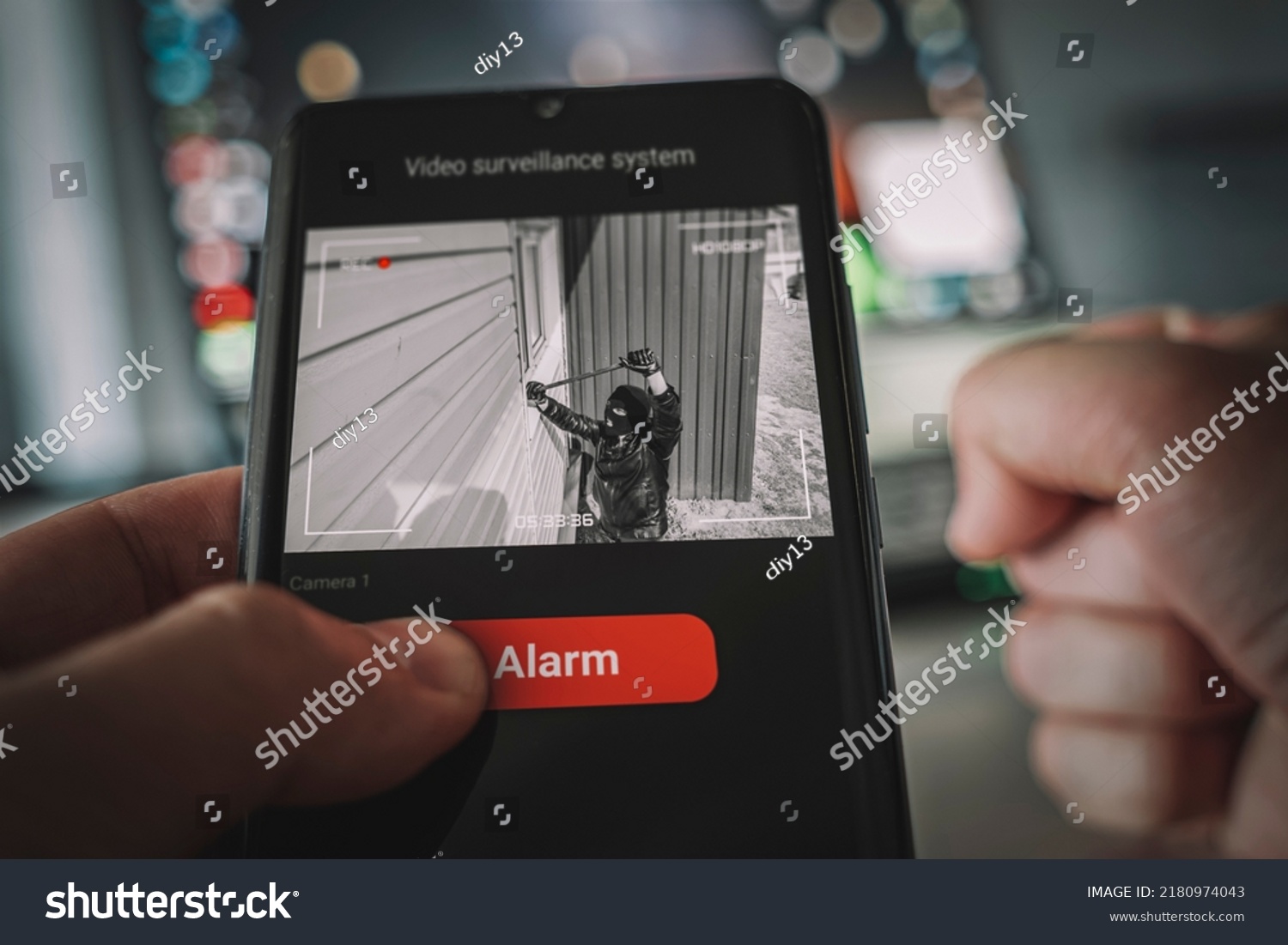 Protection of private residential building with help of an external video surveillance system. an application on smartphone screen. CCTV view of burglar breaking into home through window with crowbar. #2180974043