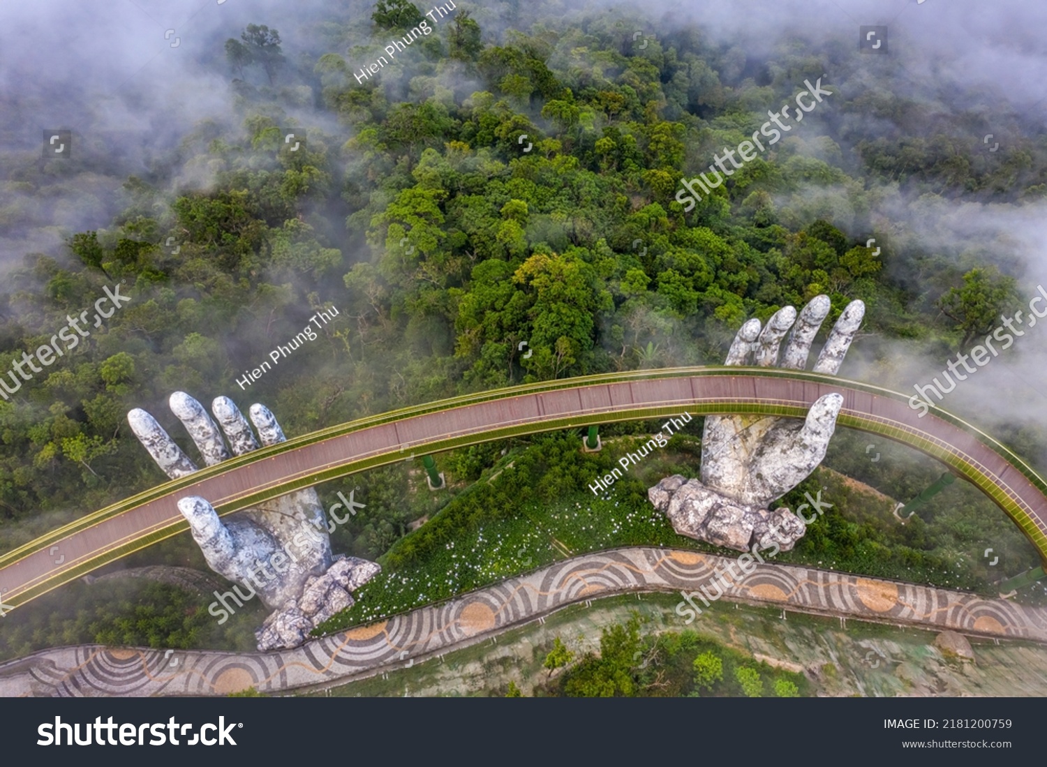 Aerial view of the Golden Bridge is lifted by two giant hands in the tourist resort on Ba Na Hill in Da Nang, Vietnam. Ba Na mountain resort is a favorite destination for tourists #2181200759