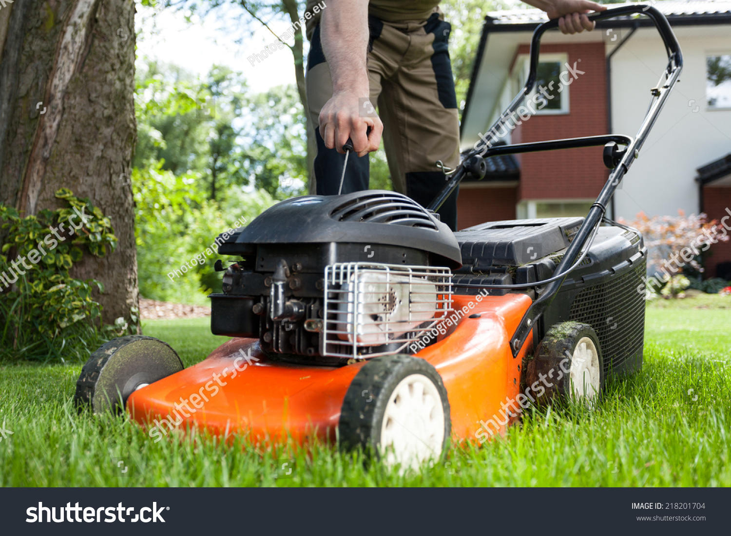 Turning on the lawn mower by gardener #218201704