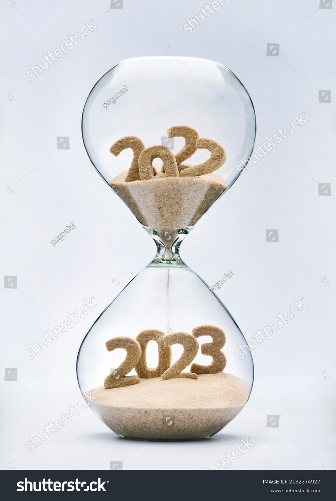New Year 2023 concept with hourglass falling sand taking the shape of a 2023 #2182274927