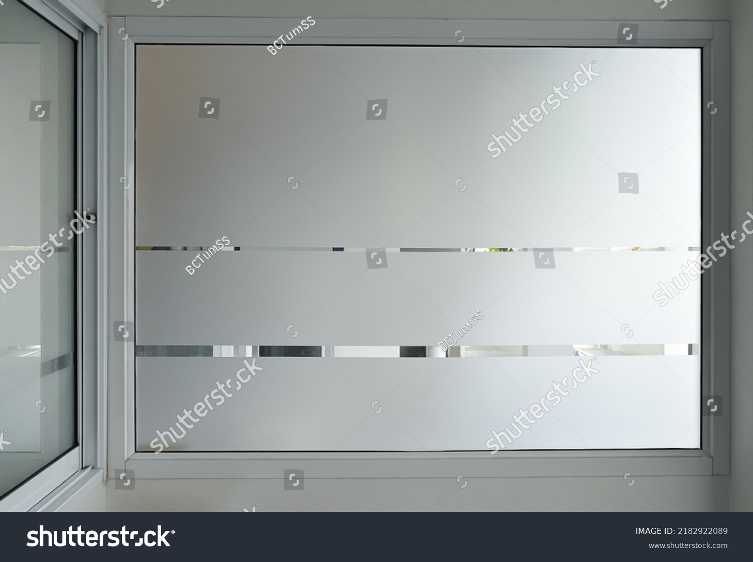 Aluminium sliding window of office. office sliding glass window. Decorative Glass Film on door of office. Closeup Frosted Glass Thick Film for reduced visibility across. #2182922089