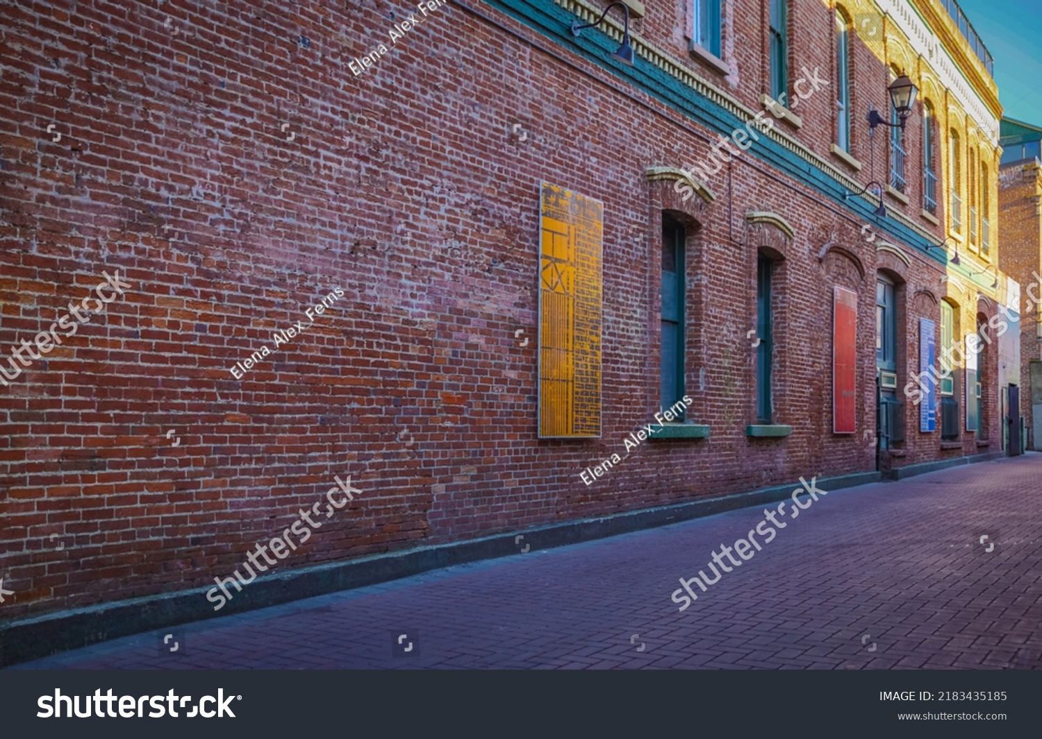 Urban Alley in old city. Old grunge street. Grungy urban background of a brick wall with windows. Travel photo, nobody, copy space for text #2183435185