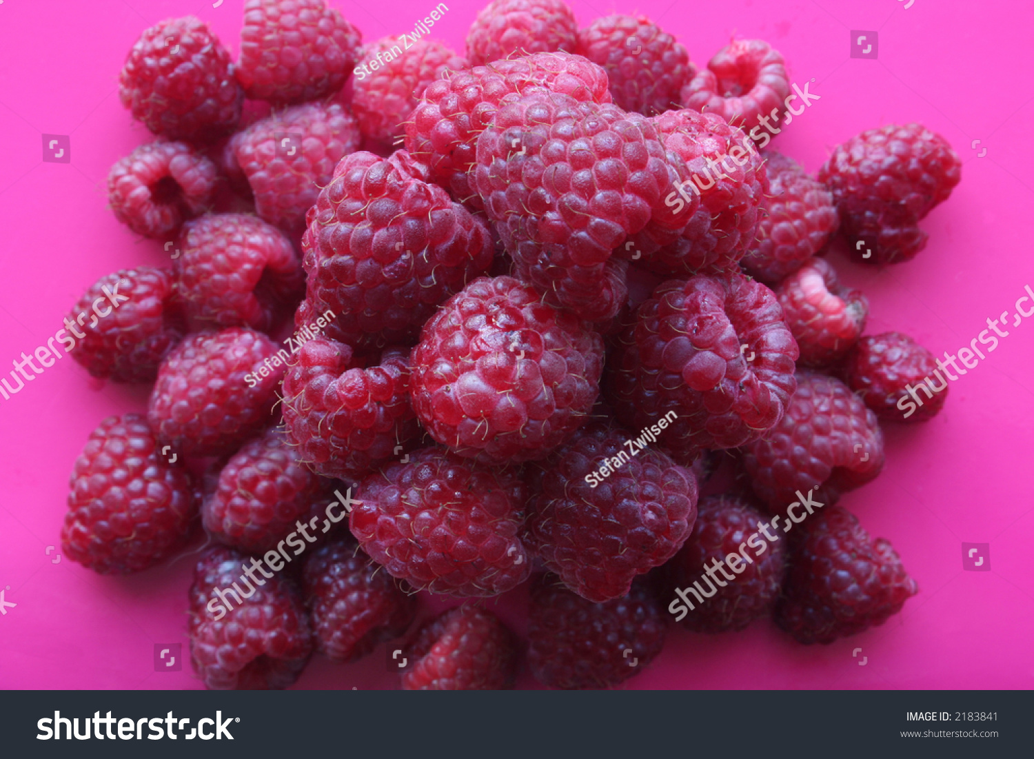 Top view of a pile of raspberries, on a pink background. #2183841