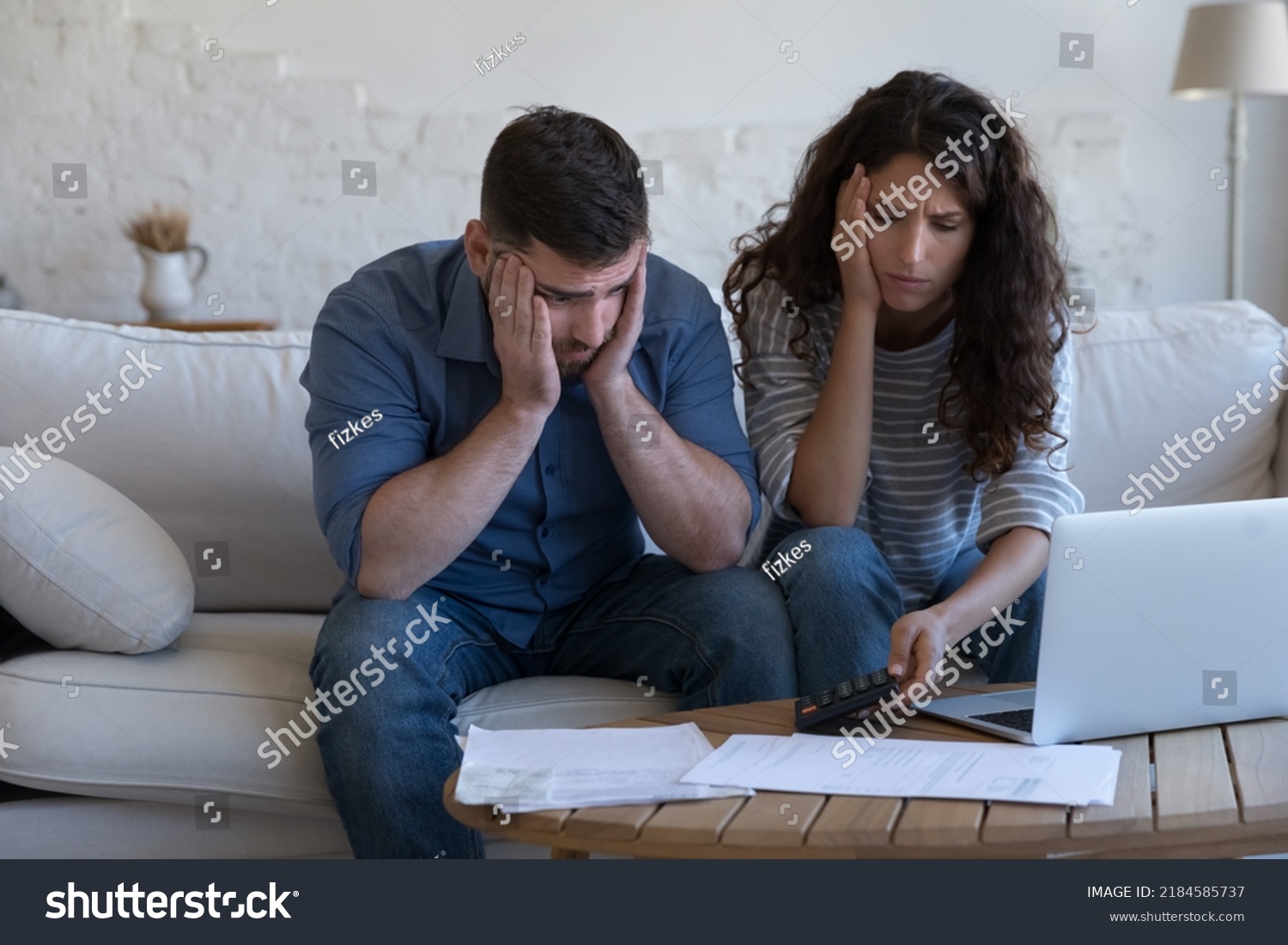 Concerned upset millennial couple counting overspent budget, doing paperwork, thinking on financial problems, high mortgage, rental fees, bad loan conditions, bankruptcy, eviction notice #2184585737