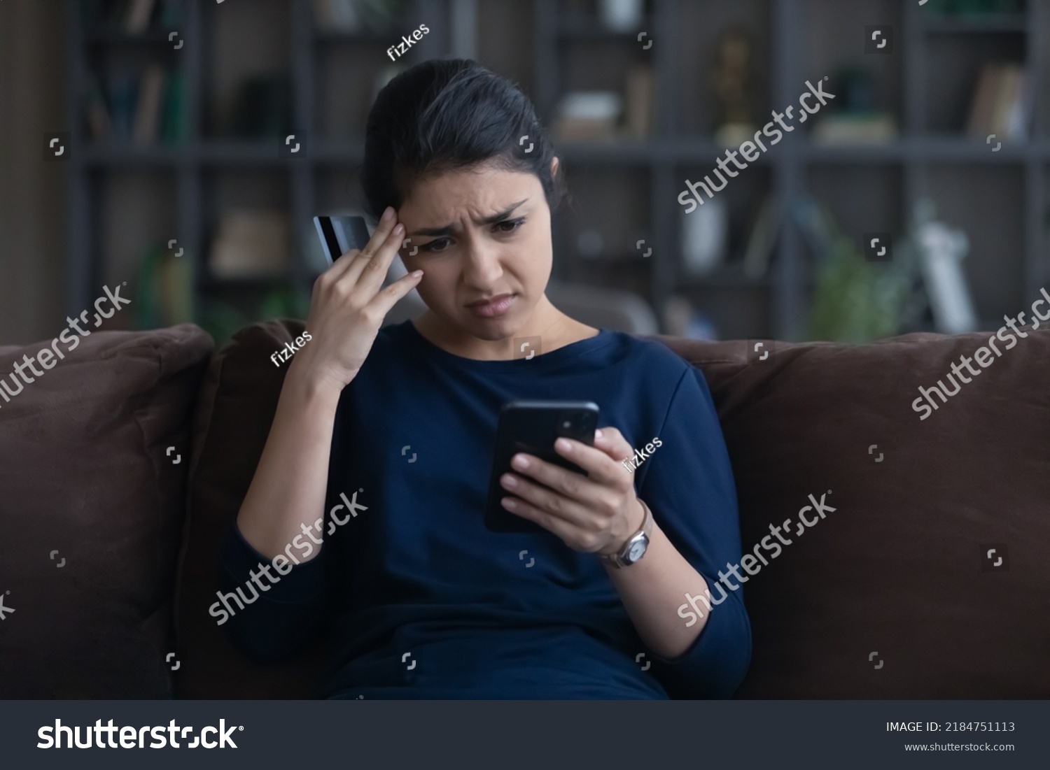 Unhappy young Indian woman distressed with payment problems shopping online from home on smartphone with credit debit card. Upset biracial female buyer frustrated with bank error on cell. #2184751113