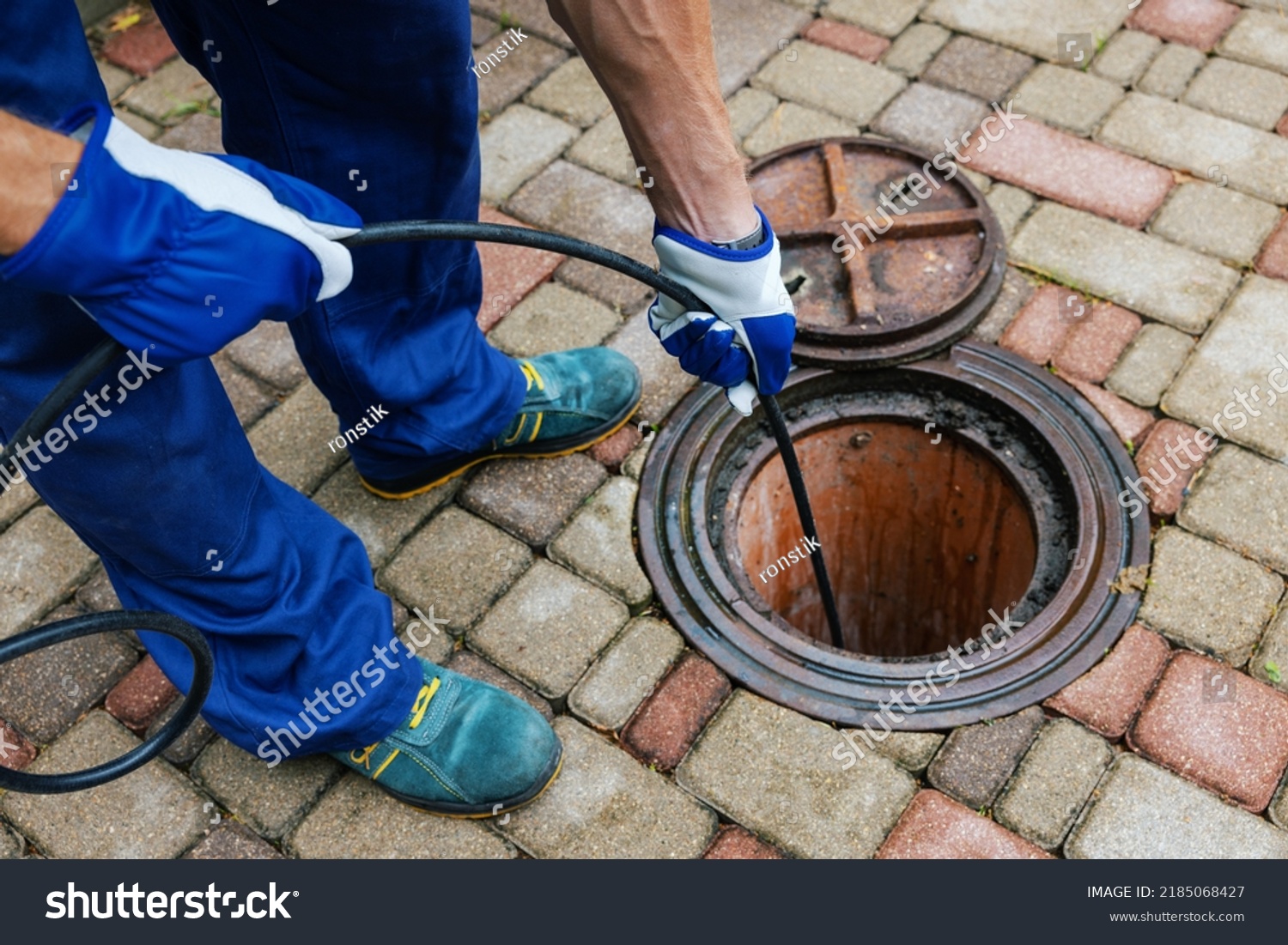 sewer cleaning service - worker clean a clogged drainage with hydro jetting #2185068427