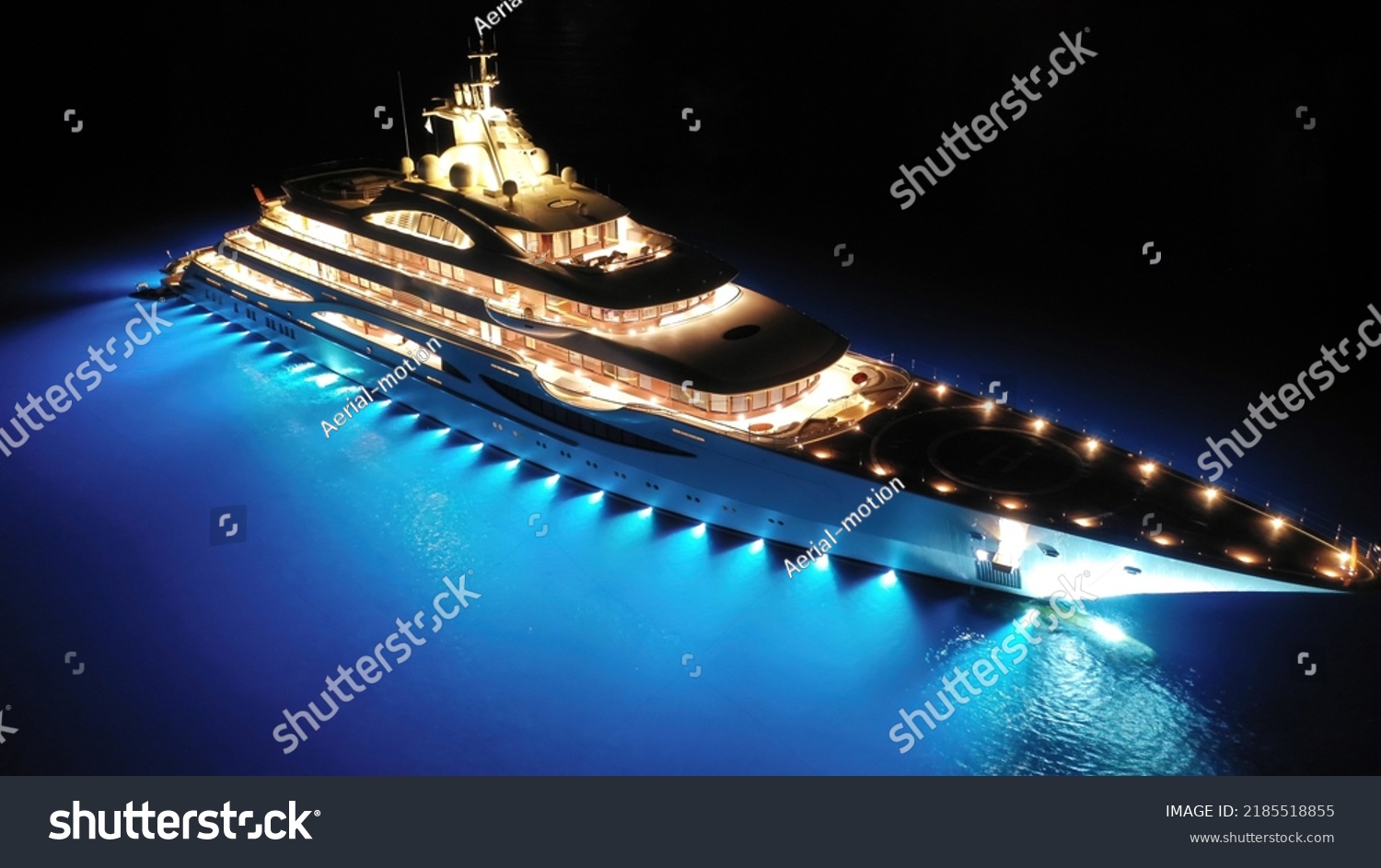 Aerial drone night shot of beautiful latest technology modern led illuminated luxury mega yacht anchored in deep blue sea of Mykonos island, Cyclades, Greece #2185518855