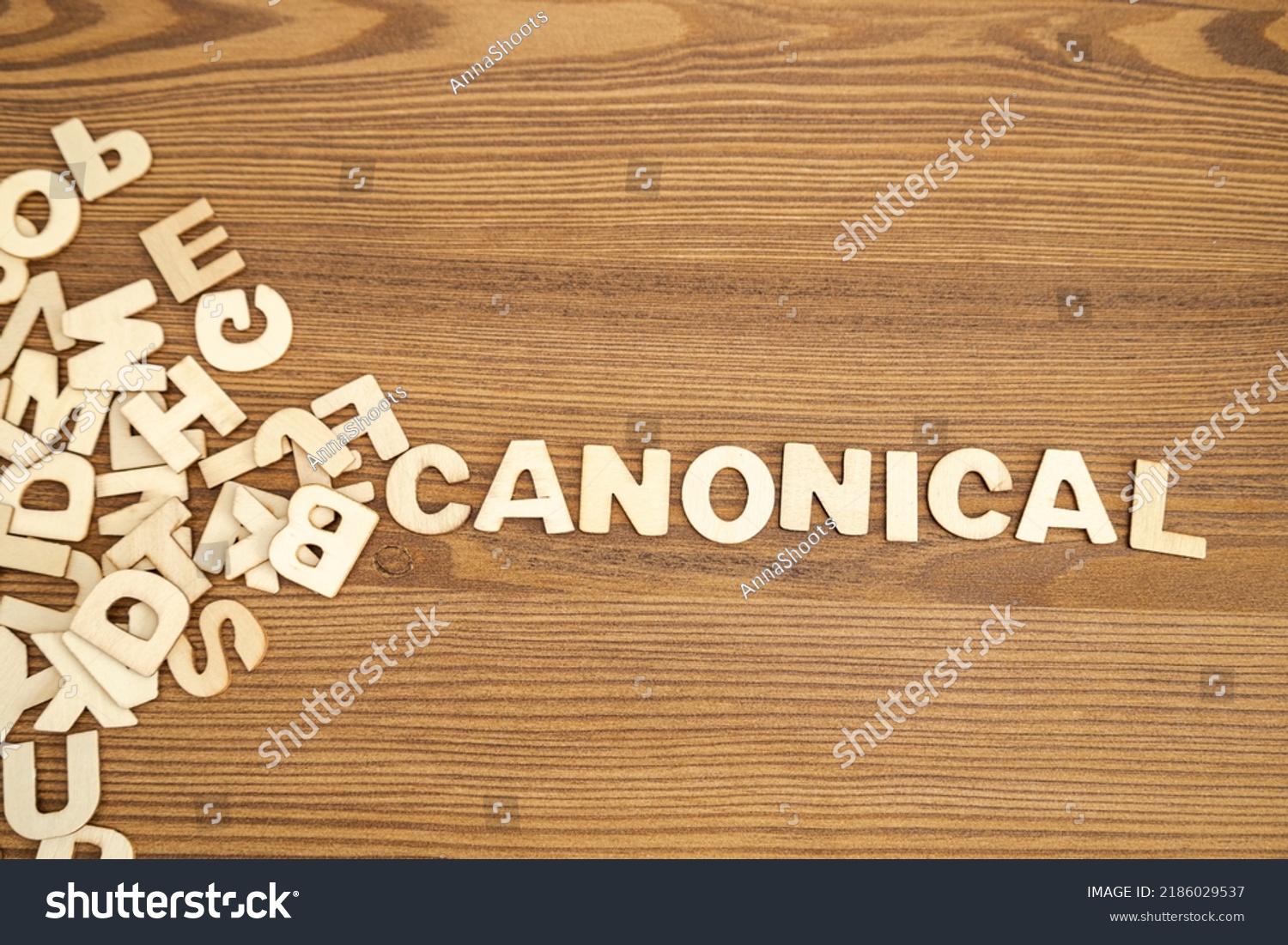 Word CANONICAL written with solid letters on a board. Wooden letters on wooden background. #2186029537
