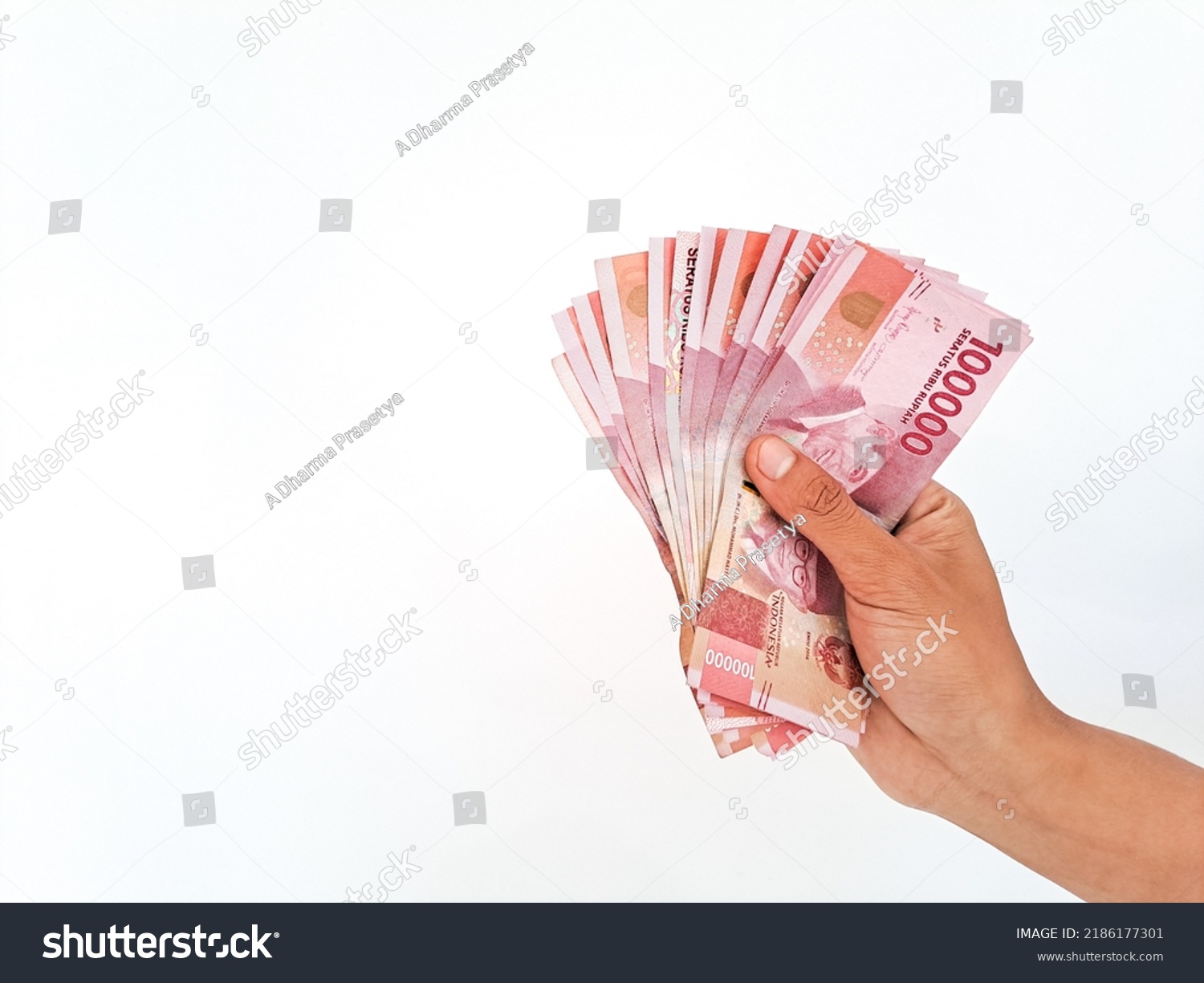 Man's Hand holding rupiah money isolates on white background #2186177301