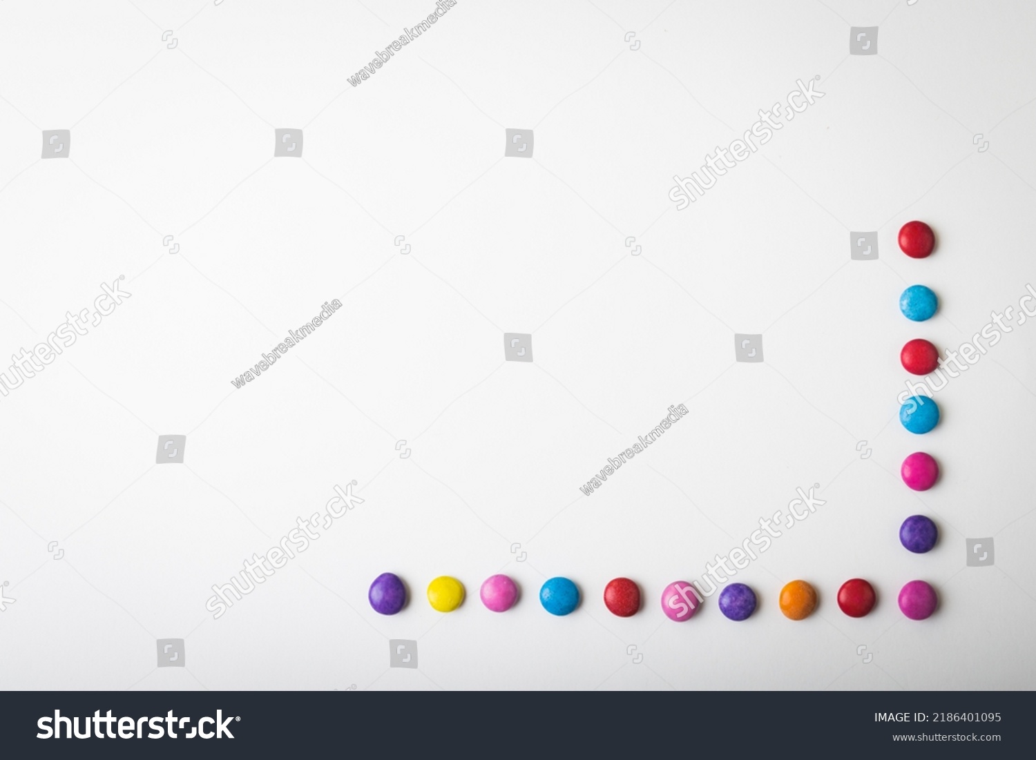 Overhead view of multi colored chocolate candies arranged by copy space over white background. unaltered, unhealthy eating and sweet food concept. #2186401095
