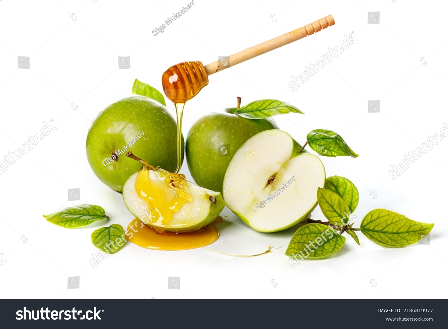 Honey dripping from wooden stick on green apples. White background. Rosh Hashanah (Jewish New Year holiday) concept. #2186819977