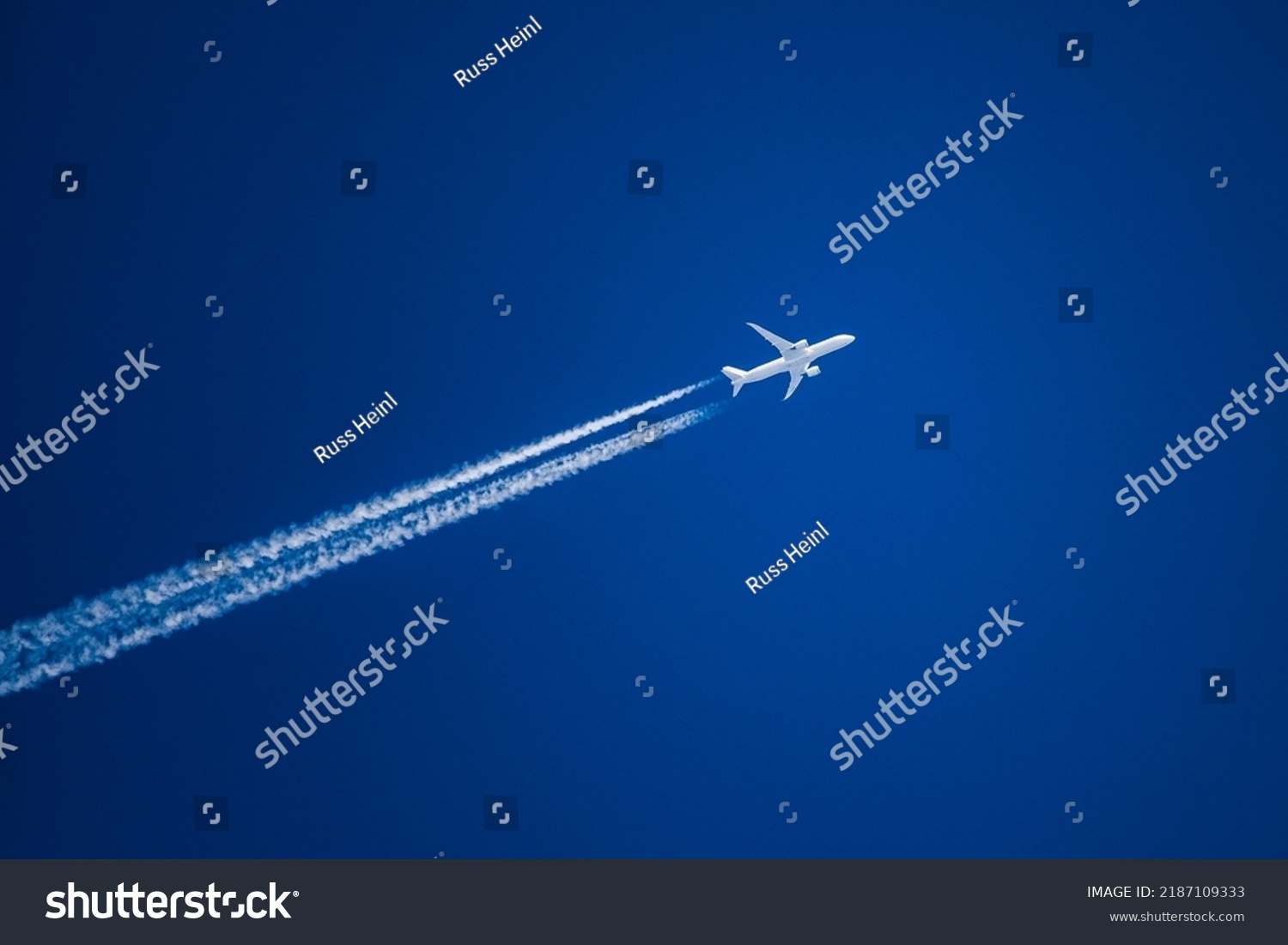 Sharp telephoto close-up of jet plane aircraft with contrails cruising from Tokyo to Boston, altitude AGL 37,000 feet, ground speed 548 knots. #2187109333