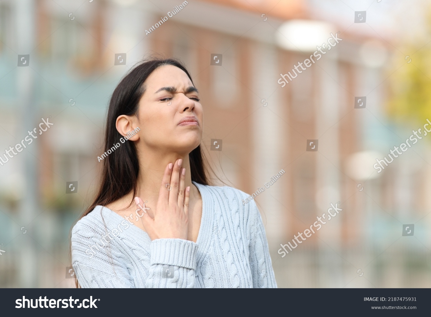 Stressed woman suffering sore throat standing in the street #2187475931