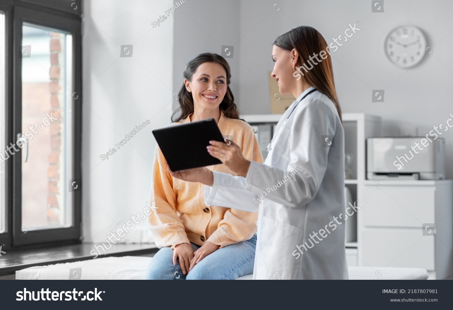 medicine, healthcare and people concept - female doctor with tablet pc computer talking to smiling woman patient at hospital #2187807981