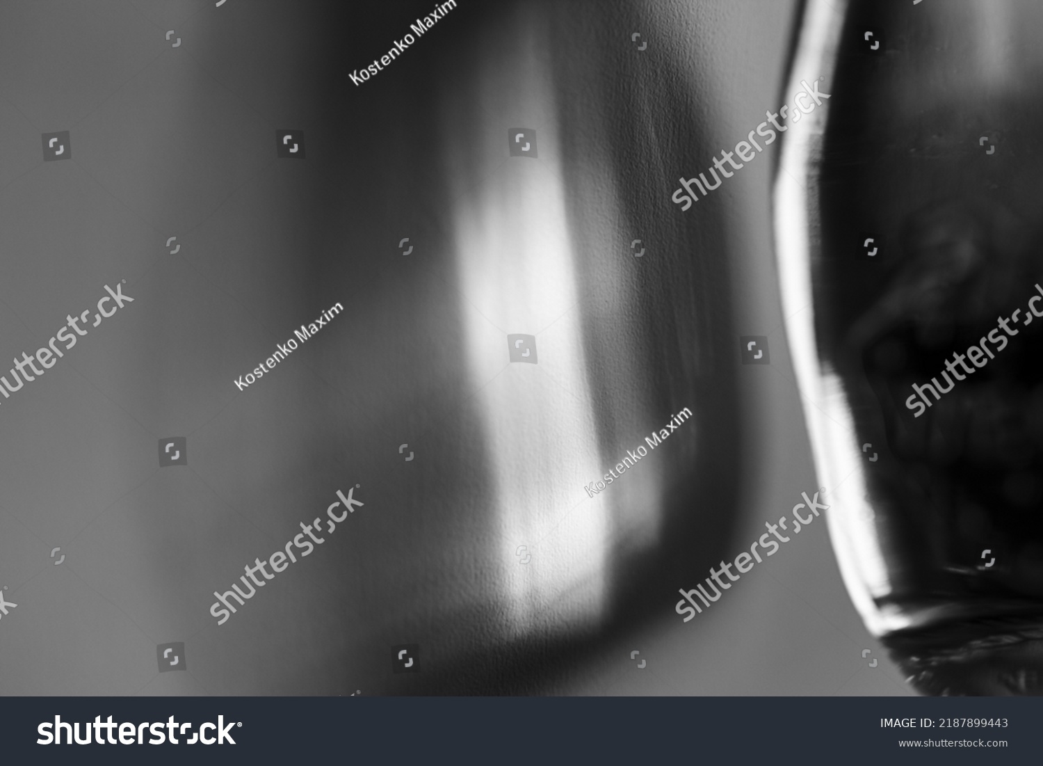 Glass bottle cast beautiful shadow and caustic effect as light passes through a glass. Black and white photo. Abstract background #2187899443