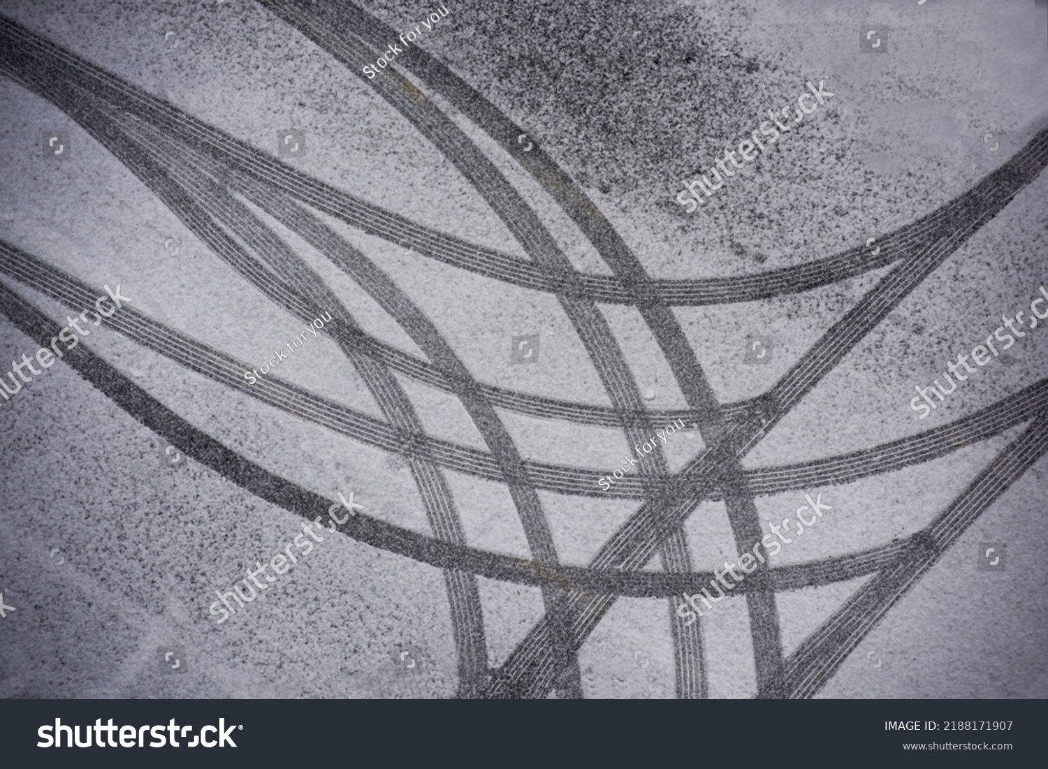Top angle view of snow covered asphalt parking lot with curved and straight wheel traces, South Korea 
 #2188171907