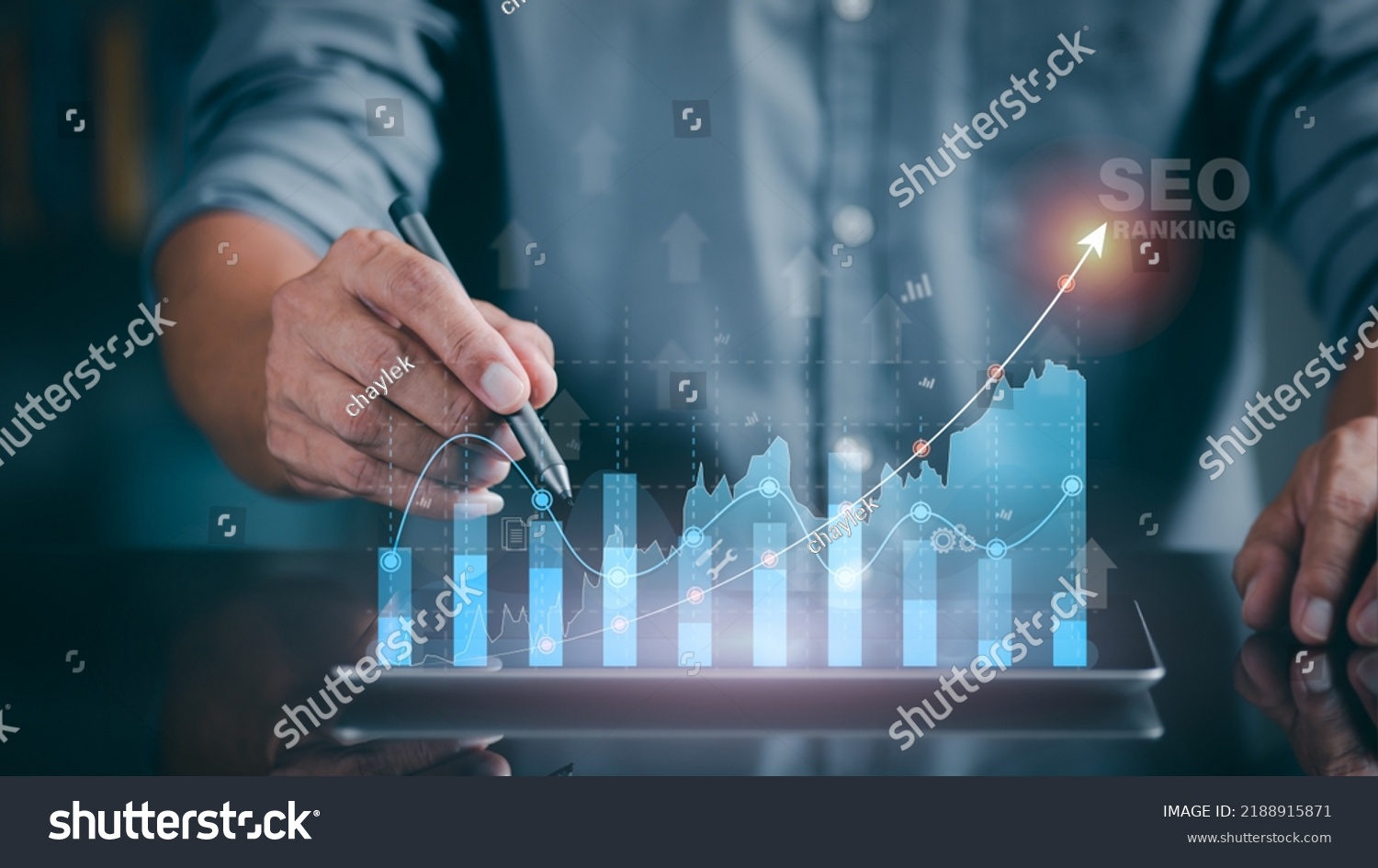 A marketer holds a pen pointing to a graph and shows SEO concepts, optimization analysis tools, search engine rankings, social media sites based on results analysis data. #2188915871