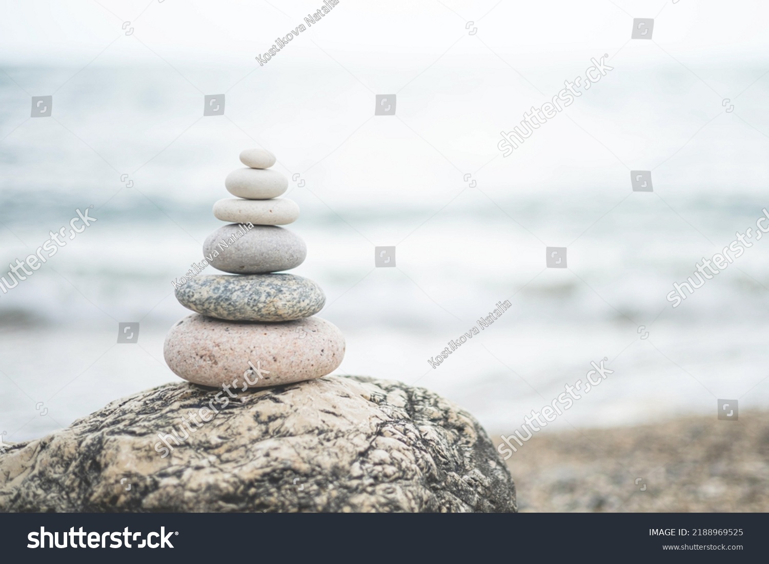 Pebble tower balance harmony stones arrangement on sea beach coastline. Relaxing peaceful formation pyramid cobblestone philosophy equilibrium spiritual tranquility. Spa therapy summer travel vacation #2188969525