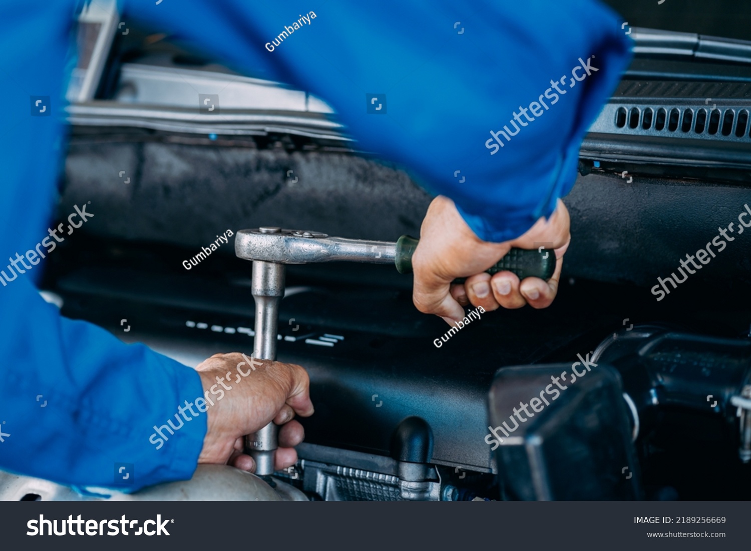 Close up of view Auto mechanic repairman using a socket wrench working engine repair in the garage, change spare part, check the mileage of the car, checking and maintenance service concept. #2189256669