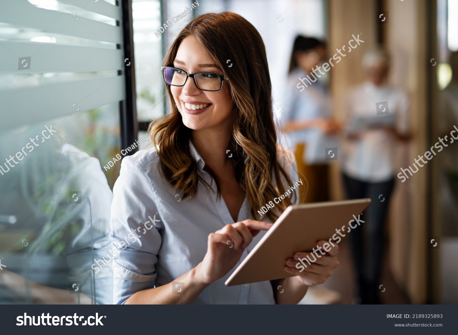 Young happy business woman working with tablet in corporate office #2189325893