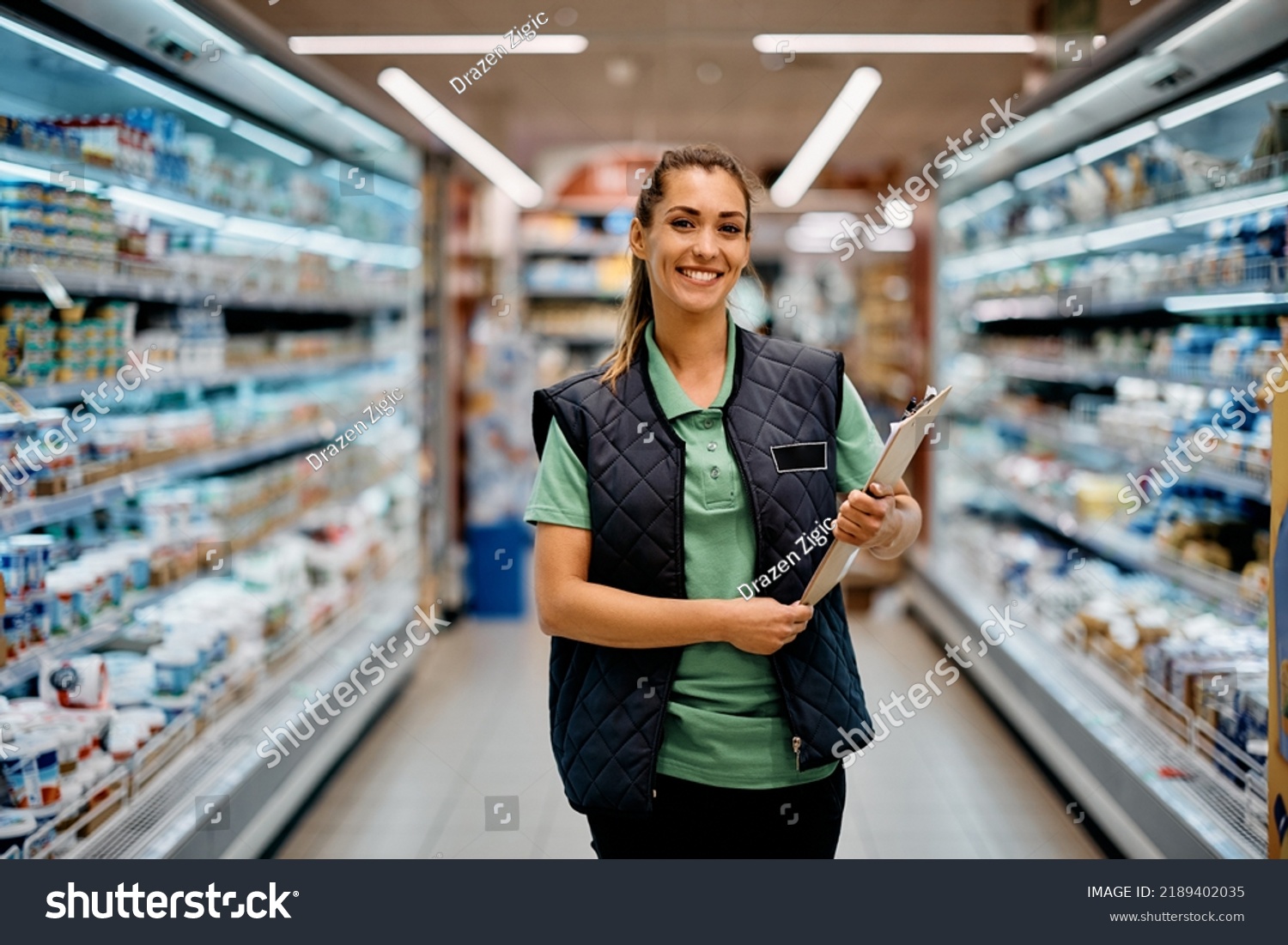 Young happy supermarket manager standing at produce aisle and looking at camera. #2189402035