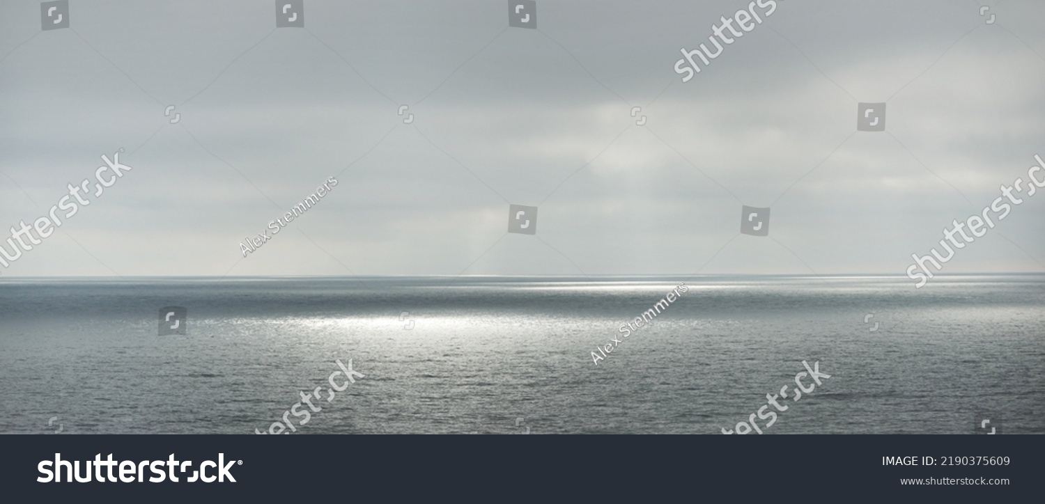 Panoramic view of the Baltic sea during the storm. Dramatic sky, sun rays through the dark clouds. Epic seascape. Finland. Concept image, ecology, meteorology, weather. Black and white, silver colors #2190375609