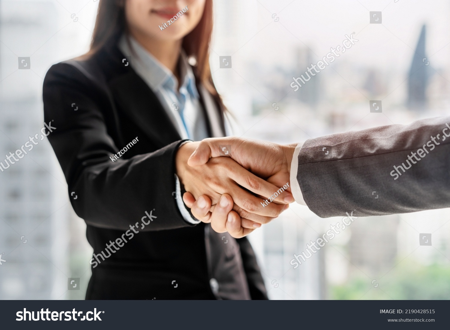 Businessman and businesswoman shaking hands, Partnership Successful deal after meeting with skyscrapers background, Business cooperation concept #2190428515