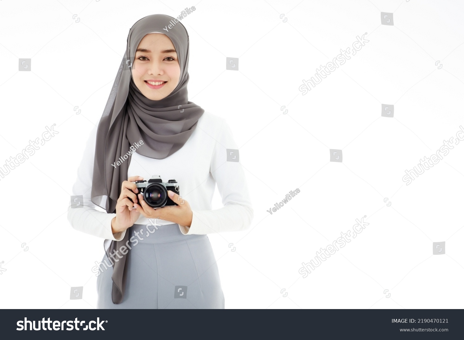 Young beautiful young Asian Islamic businesswoman holding a vintage camera. Muslim women concept with hobbies and art photography. #2190470121
